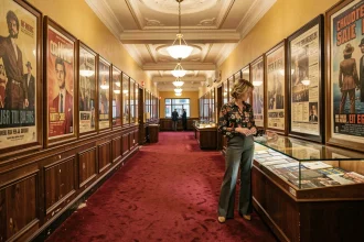 Lobby de cinéma rétro des années 70 avec affiches de films vintage et femme en tenue d'époque