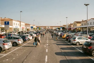 Parking bondé d'un centre commercial à Miramas lors d'un grand week-end, voitures garées sur toutes les places disponibles